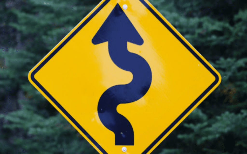 Yellow winding road sign ahead.