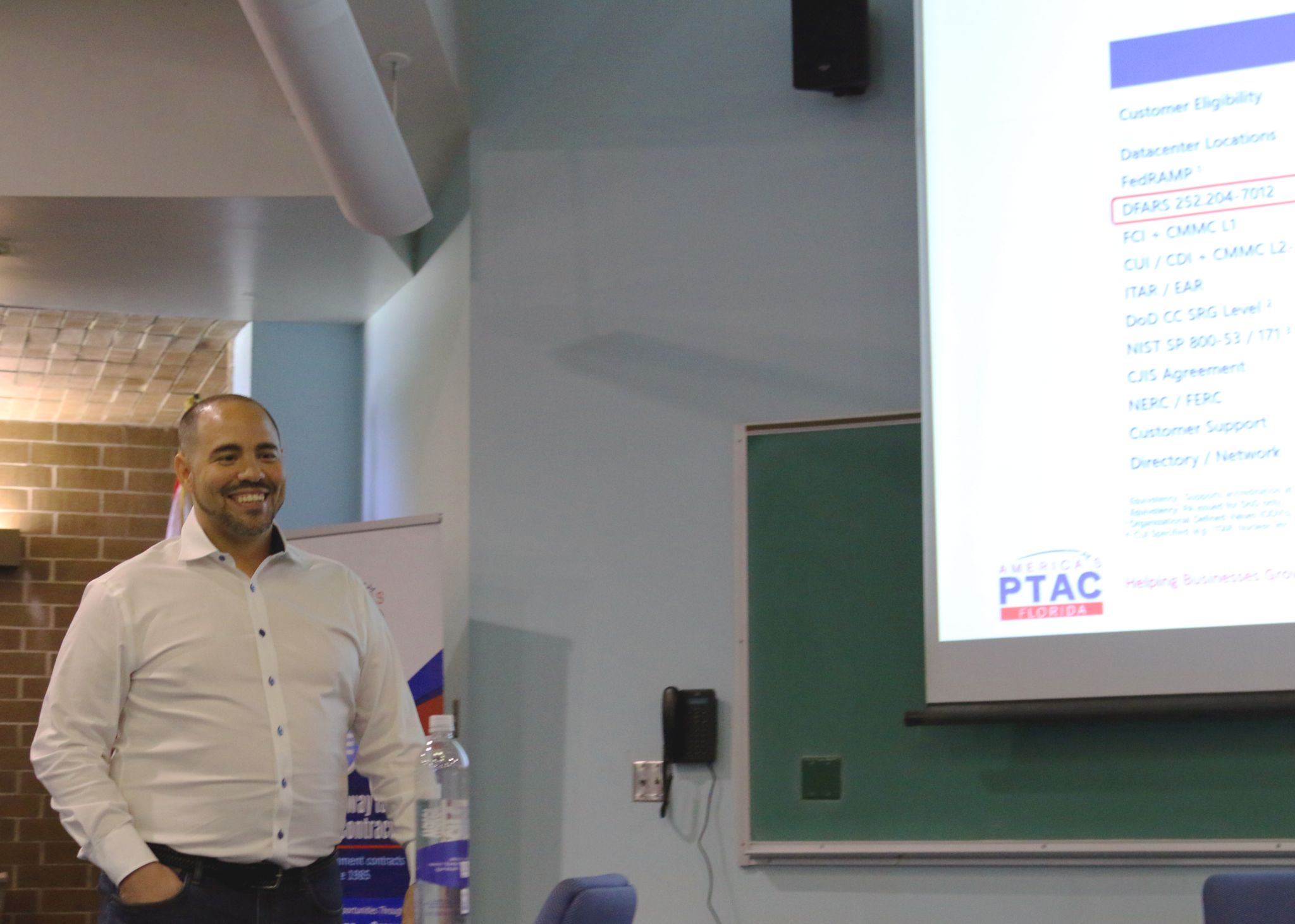 A man standing in front of a projector screen.