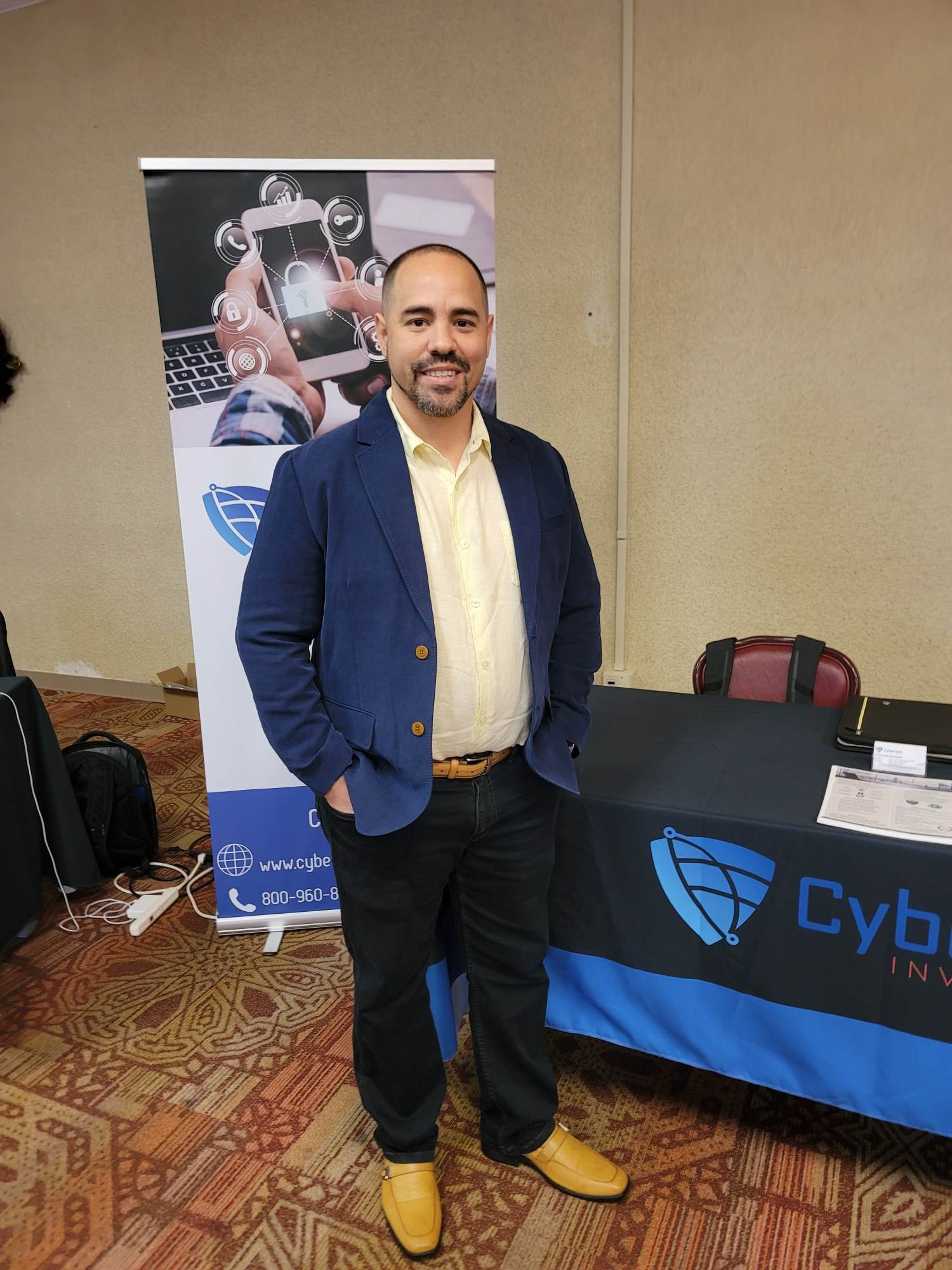 A man standing in front of a table with a sign.