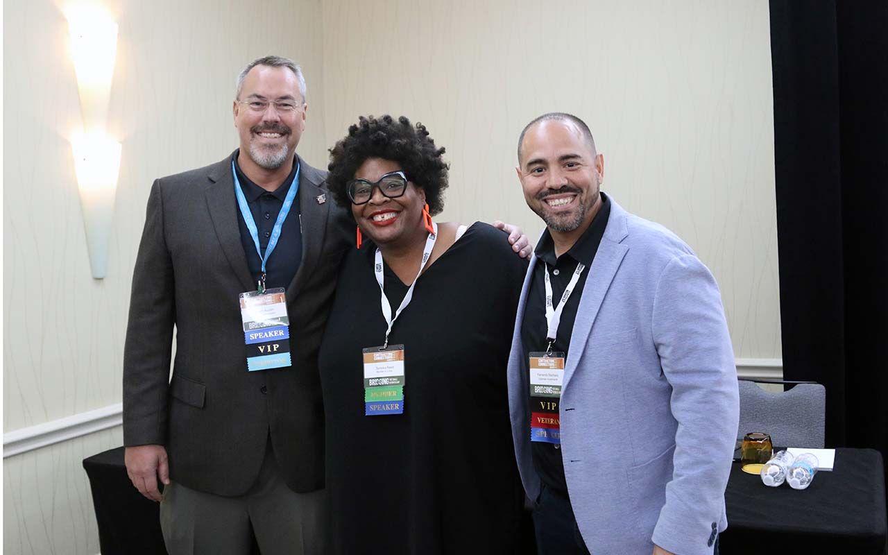 Three people posing for a picture at an event.