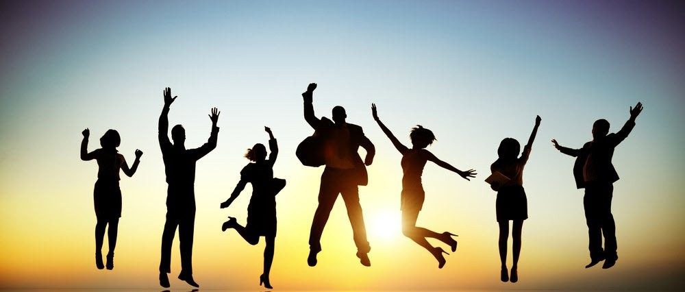 Silhouetted business people joyfully jumping.