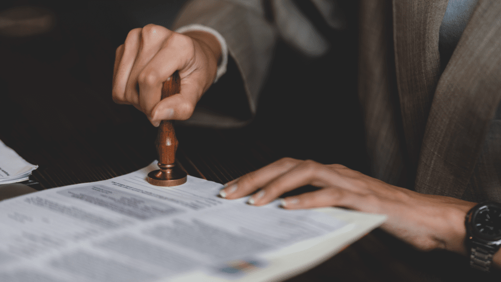 Person stamping document with seal.