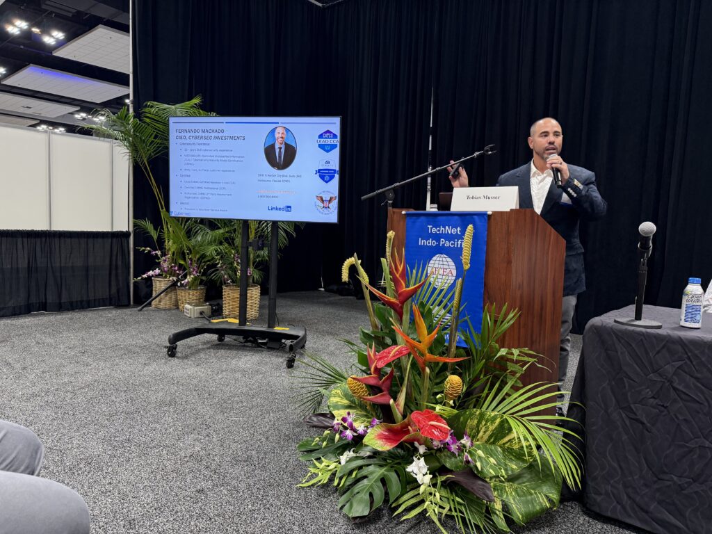 Man speaking at podium beside presentation screen