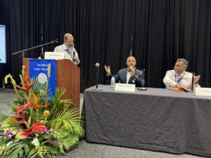 Three panelists speaking at conference table
