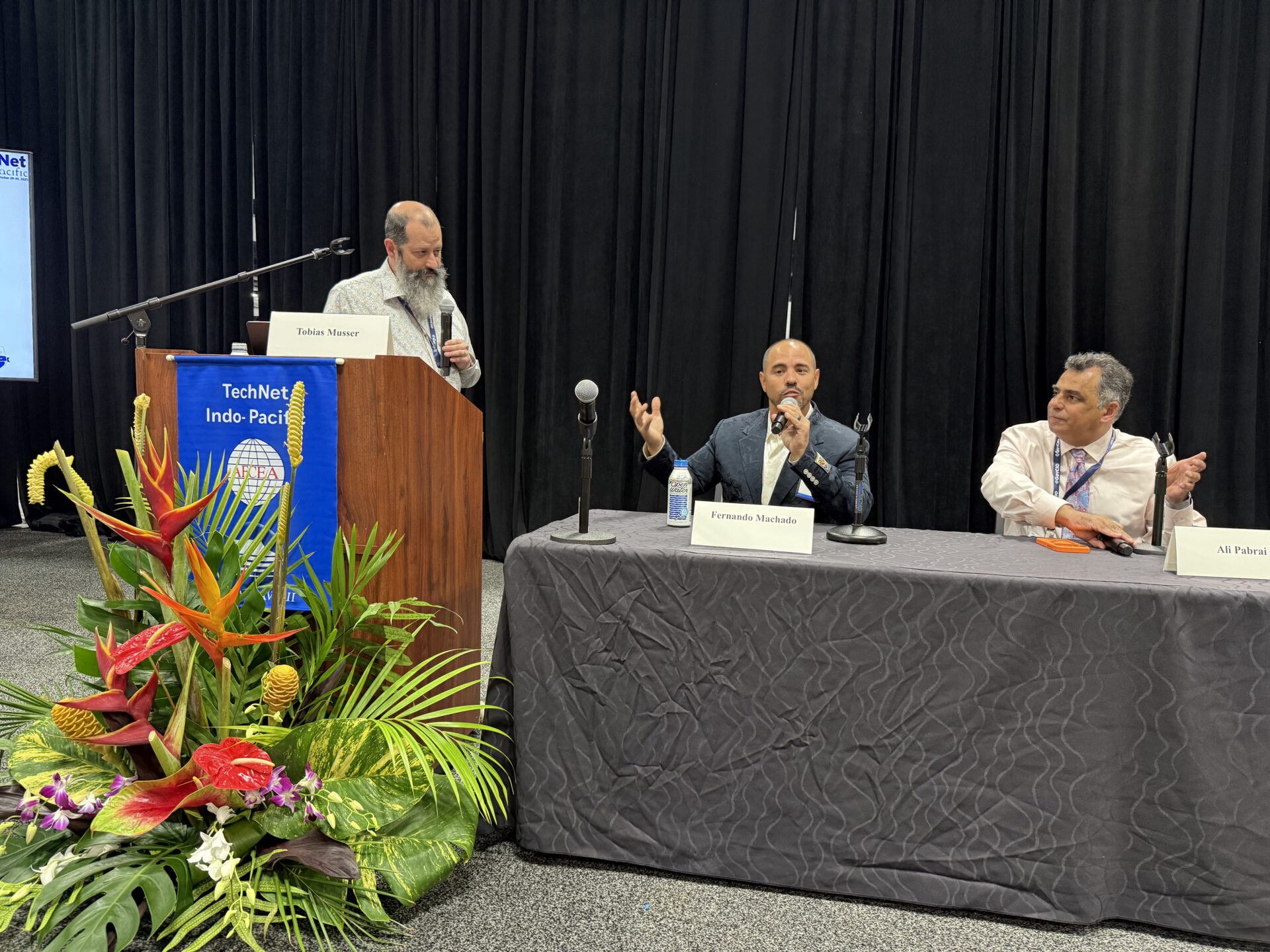 Three panelists speaking at conference table