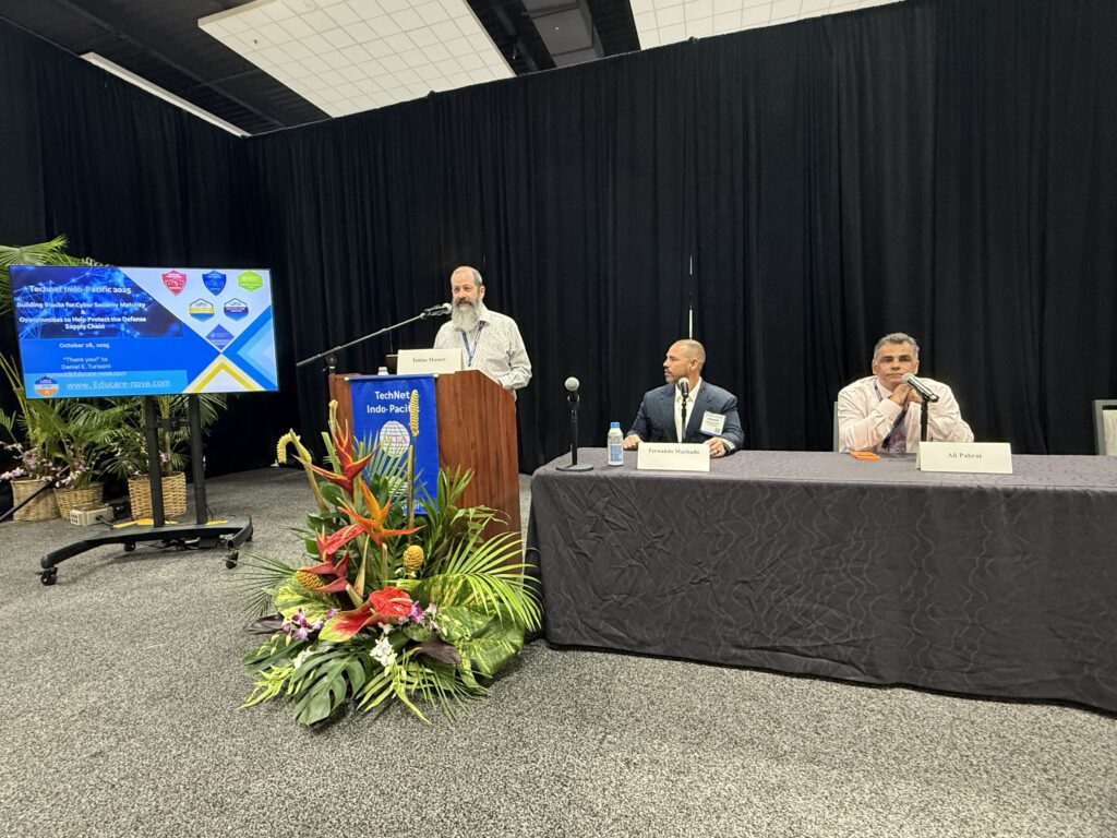 Speaker at podium with two panelists
