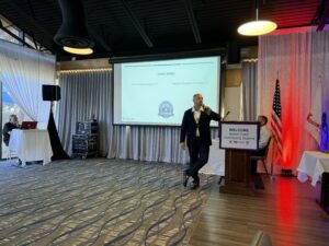 Speaker presenting at conference with projection screen