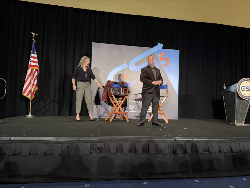 Two people on stage during a presentation.