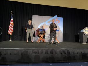 Two people on stage during a presentation.