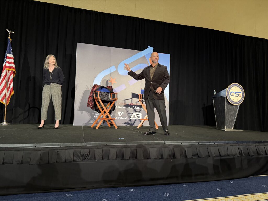 Two people on stage at a conference.